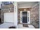 Close-up of the front door, garage, and house numbers at 9862 Walkers Glen Nw Dr, Concord, NC 28027