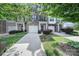 Charming brick townhome featuring an attached garage, well-maintained lawn, and mature trees at 9862 Walkers Glen Nw Dr, Concord, NC 28027