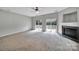 A bright and airy living room featuring a fireplace and sliding doors leading to a balcony at 9862 Walkers Glen Nw Dr, Concord, NC 28027