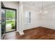 Elegant dining room featuring hardwood floors, wainscoting, a modern chandelier, and abundant natural light at 1004 Toquima Trl, Monroe, NC 28110