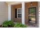 Inviting front porch with brick accents, decorative columns, and a glass front door at 1004 Toquima Trl, Monroe, NC 28110