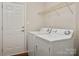 Well-equipped laundry area with modern appliances, storage shelf, and a convenient exterior door at 1004 Toquima Trl, Monroe, NC 28110