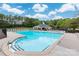 Community pool area surrounded by lounge chairs, landscaping, and a pool house at 1004 Toquima Trl, Monroe, NC 28110