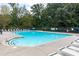 Community pool surrounded by fencing and lounge chairs, perfect for relaxation at 1004 Toquima Trl, Monroe, NC 28110