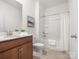 Bright bathroom featuring a shower-tub combo, ceramic tile floors, and wooden vanity with white countertops at 1034 Mapletree Ln, Indian Trail, NC 28079