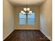 Dining room with hardwood flooring, a chandelier, and a large window providing plenty of natural light at 1034 Mapletree Ln, Indian Trail, NC 28079