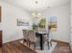 Bright dining room with modern lighting, seating for six, and hardwood floors at 1034 Mapletree Ln, Indian Trail, NC 28079