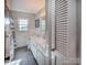 Bright bathroom featuring a double vanity, tiled backsplash, and large windows at 153 Coachman Loop, Statesville, NC 28625