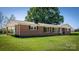 Charming, one story brick home features a lush green lawn and classic architectural details at 153 Coachman Loop, Statesville, NC 28625
