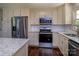 Modern kitchen featuring stainless steel appliances, white cabinetry, granite countertops, and hardwood flooring at 153 Coachman Loop, Statesville, NC 28625