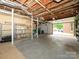 Spacious basement with exposed ceiling, shelves, and a walkout garage door at 1596 Clayton Dr, Charlotte, NC 28203