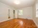 A spacious bedroom with hardwood floors, white walls, and view to an adjoining bathroom at 1596 Clayton Dr, Charlotte, NC 28203