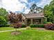 Charming brick home with a manicured lawn, mature landscaping, and inviting walkway at 1596 Clayton Dr, Charlotte, NC 28203