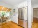 Bright kitchen with white cabinets, stainless steel fridge, and a sunroom with wood ceiling in the background at 1596 Clayton Dr, Charlotte, NC 28203