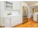 Kitchen featuring white cabinets, quartz countertops, stainless steel fridge, and wood floors at 1596 Clayton Dr, Charlotte, NC 28203