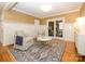 Living room with wood floors, white wainscoting, textured wallpaper, and french doors to the sunroom at 1596 Clayton Dr, Charlotte, NC 28203