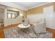 Living room featuring hardwood floors, white wainscoting, textured wallpaper, and a decorative area rug at 1596 Clayton Dr, Charlotte, NC 28203