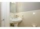 Bright powder room features a pedestal sink, tiled walls and a decorative mirror adding character and charm to the space at 1596 Clayton Dr, Charlotte, NC 28203