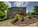 Large brick home with a tiered backyard, landscaped flower beds, and a wooden deck at 16519 Flintrock Falls Ln, Charlotte, NC 28278