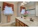 Bathroom featuring double vanity, brown cabinets, neutral walls, and large mirror at 16519 Flintrock Falls Ln, Charlotte, NC 28278