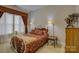 The bedroom is adorned with red patterned bedding, complemented by matching window treatments, two side tables and lamps at 16519 Flintrock Falls Ln, Charlotte, NC 28278