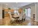 A well-lit dining area adjacent to the kitchen features a wooden table, upholstered chairs, and an intricate area rug at 16519 Flintrock Falls Ln, Charlotte, NC 28278