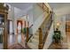 The spacious foyer features hardwood floors, a staircase with wooden railings, and decorative plants at 16519 Flintrock Falls Ln, Charlotte, NC 28278