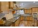 A well-equipped kitchen boasts granite countertops, stainless steel appliances, ample cabinetry, and hardwood floors at 16519 Flintrock Falls Ln, Charlotte, NC 28278