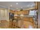 The kitchen has a black island with granite countertop, wooden cabinets, stainless steel appliances, and hardwood floors at 16519 Flintrock Falls Ln, Charlotte, NC 28278