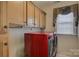 The laundry room features wooden cabinets for storage and modern washer and dryer units at 16519 Flintrock Falls Ln, Charlotte, NC 28278