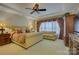 A spacious main bedroom featuring a decorative ceiling fan and large window with decorative valance at 16519 Flintrock Falls Ln, Charlotte, NC 28278