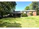 Spacious backyard features a well-maintained lawn, covered patio, and a brick home with ample natural light at 17389 Mooresville Rd, Mooresville, NC 28115
