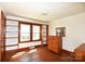 Bright bedroom with hardwood floors, built-in shelving, and natural light streaming through the window at 17389 Mooresville Rd, Mooresville, NC 28115