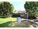 Charming brick home with lush landscaping, mature trees, and a covered porch, blending natural beauty and curb appeal at 17389 Mooresville Rd, Mooresville, NC 28115