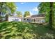 Expansive backyard featuring a detached garage, deck, and lush greenery for outdoor enjoyment at 1938 Dembrigh Ln, Charlotte, NC 28262