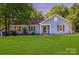 Charming blue home featuring a well-manicured lawn and a welcoming covered entryway at 1938 Dembrigh Ln, Charlotte, NC 28262
