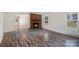 Living room showcasing a brick fireplace and updated wood-look flooring at 1938 Dembrigh Ln, Charlotte, NC 28262