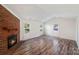 Bright living room featuring a brick fireplace, hardwood floors, and large windows at 1938 Dembrigh Ln, Charlotte, NC 28262