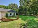 Expansive backyard with green lawn, brick retaining wall, leading to a detached garage at 2018 Radcliffe Ave, Charlotte, NC 28207