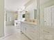 Bright bathroom featuring double vanity, tub, walk-in shower, and elegant white cabinetry and marble countertops at 2018 Radcliffe Ave, Charlotte, NC 28207