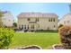 Sprawling backyard showcases a patio with furniture, well-maintained lawn, and mature trees for shade at 2036 E Foxwood Ct, Indian Land, SC 29707