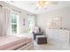 Bedroom with twin bed, a gray chair, ottoman, and natural light from two large windows at 2036 E Foxwood Ct, Indian Land, SC 29707