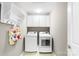 Efficient laundry room with overhead rack and cabinets and modern appliances, including washer and dryer at 2036 E Foxwood Ct, Indian Land, SC 29707