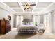 Comfortable main bedroom featuring a tray ceiling, ceiling fan, and light gray walls and carpet at 2036 E Foxwood Ct, Indian Land, SC 29707