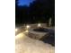 Outdoor stone fire pit with accent lighting in the evening at 205 Commodore Ct, Belmont, NC 28012