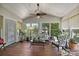 Inviting sunroom featuring wood floors, many windows, and a ceiling fan, perfect for relaxation and enjoying the natural light at 205 Commodore Ct, Belmont, NC 28012