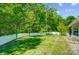 Spacious backyard featuring a well-maintained lawn, white fence, and lush tree line at 2113 London Ln, Belmont, NC 28012