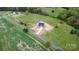 A high angle aerial showcases a newly built home surrounded by green fields and road access on a spacious lot at 2133 Tite Rd, Stanfield, NC 28163