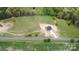 An aerial view shows a modern home on a large lot with a long driveway and surrounding trees at 2133 Tite Rd, Stanfield, NC 28163
