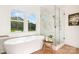 Spa-like bathroom featuring a freestanding tub, a glass shower, large windows, and modern finishes at 2133 Tite Rd, Stanfield, NC 28163
